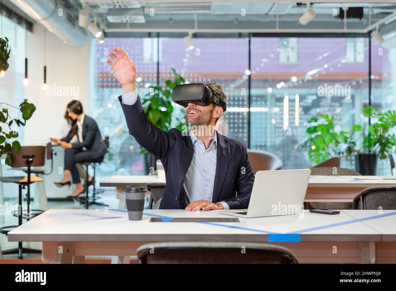 Manager wearing VR googles and gesturing in modern office Stock Photo ...