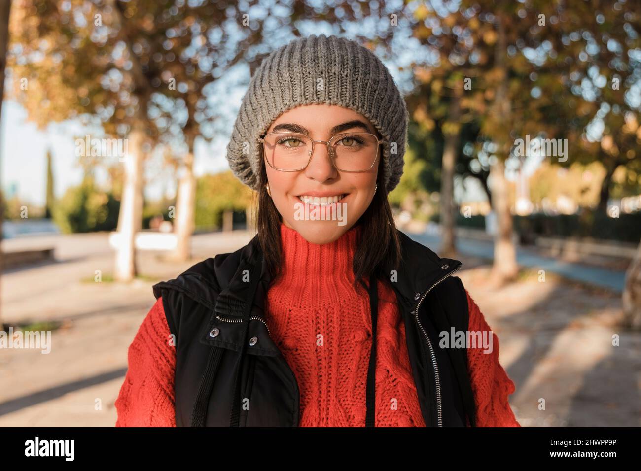 Happy young woman wearing knit hat and eyeglasses Stock Photo