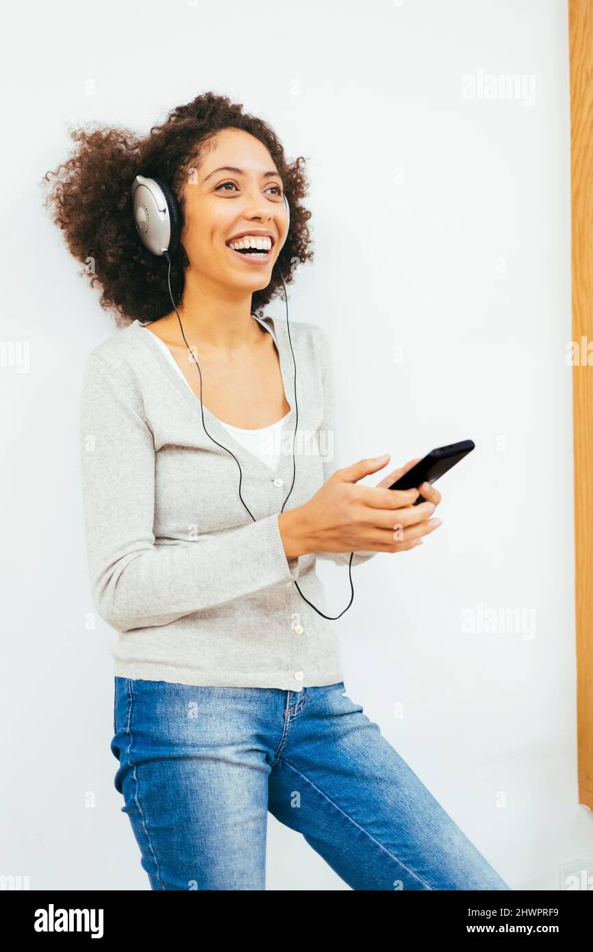 Happy woman listening music through headphones Stock Photo - Alamy