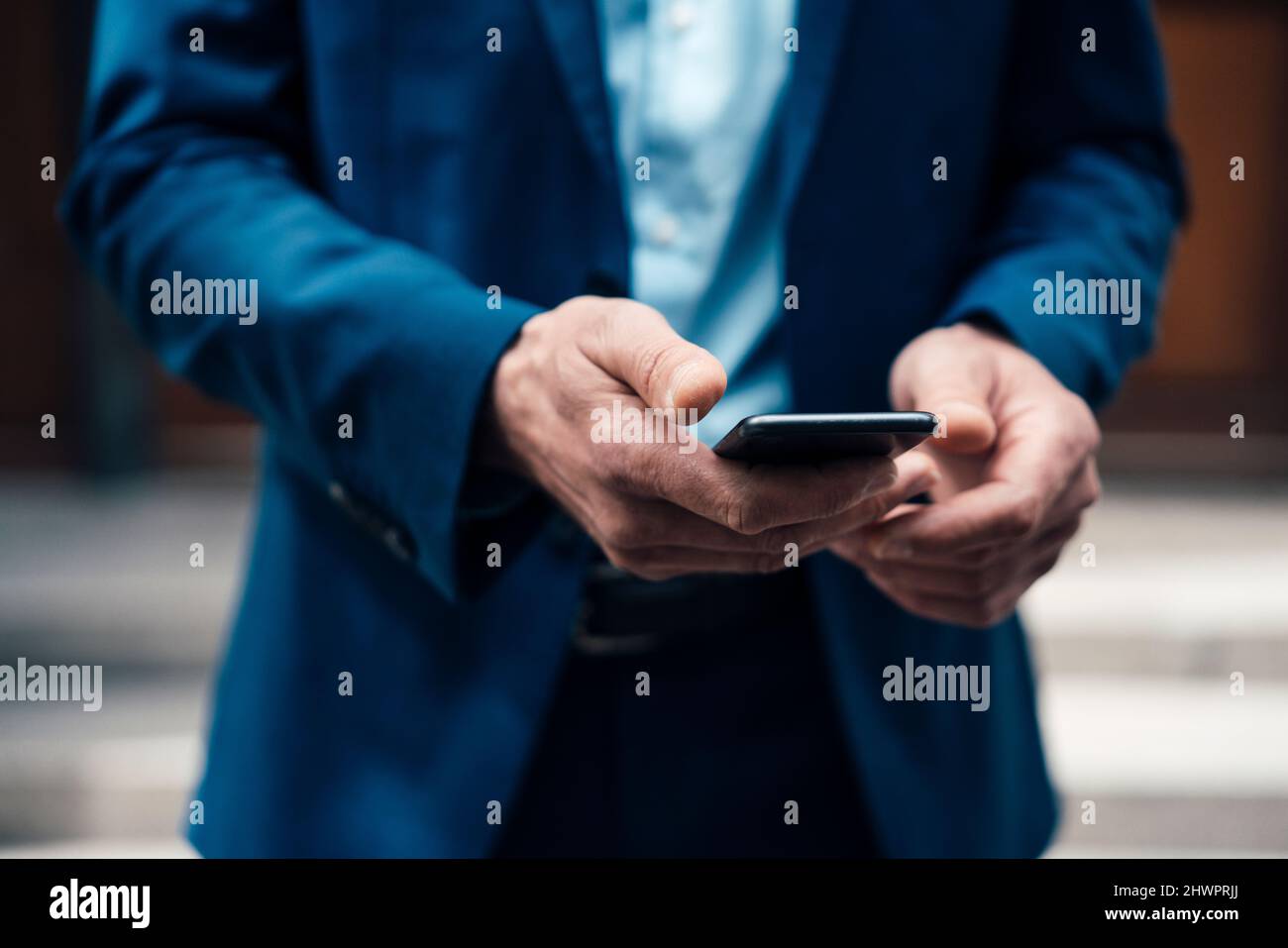 Businessman text messaging through smart phone Stock Photo