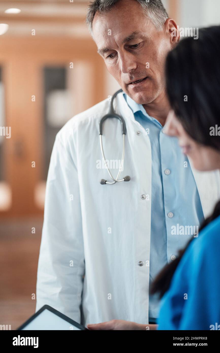 Nurse discussing with doctor over tablet PC in hospital Stock Photo