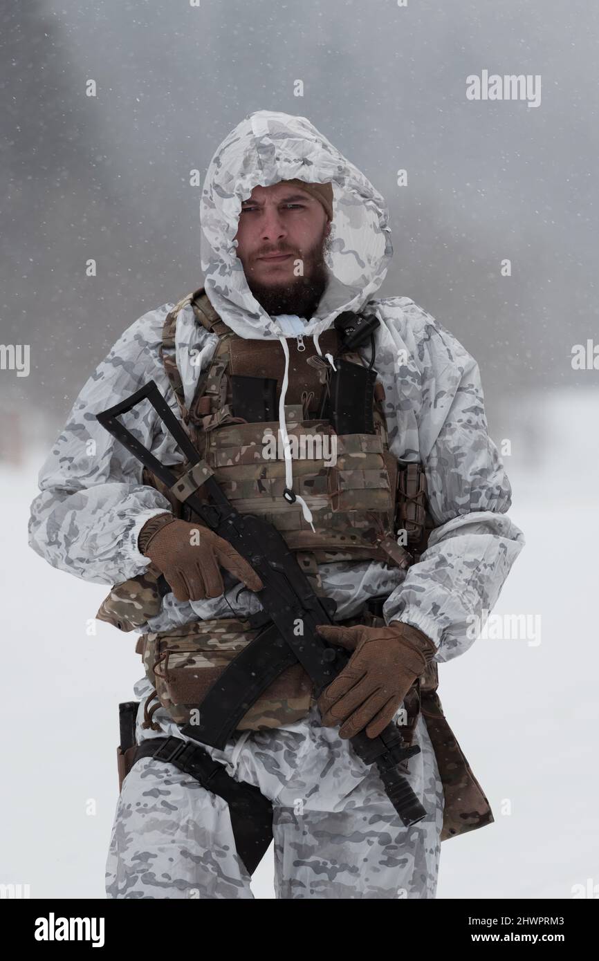 Soldier in winter camouflaged uniform in Modern warfare army on a snow day  on forest battlefield with a rifle. Model face very similar to Ukraine  Stock Photo - Alamy