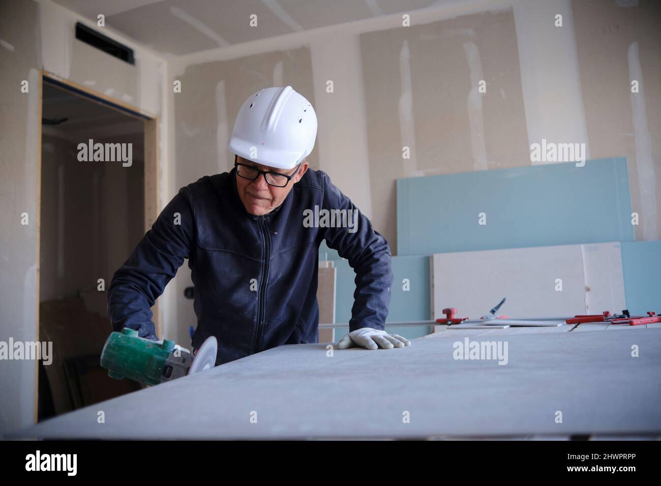 Concentrated worker with power tool at construction site Stock Photo