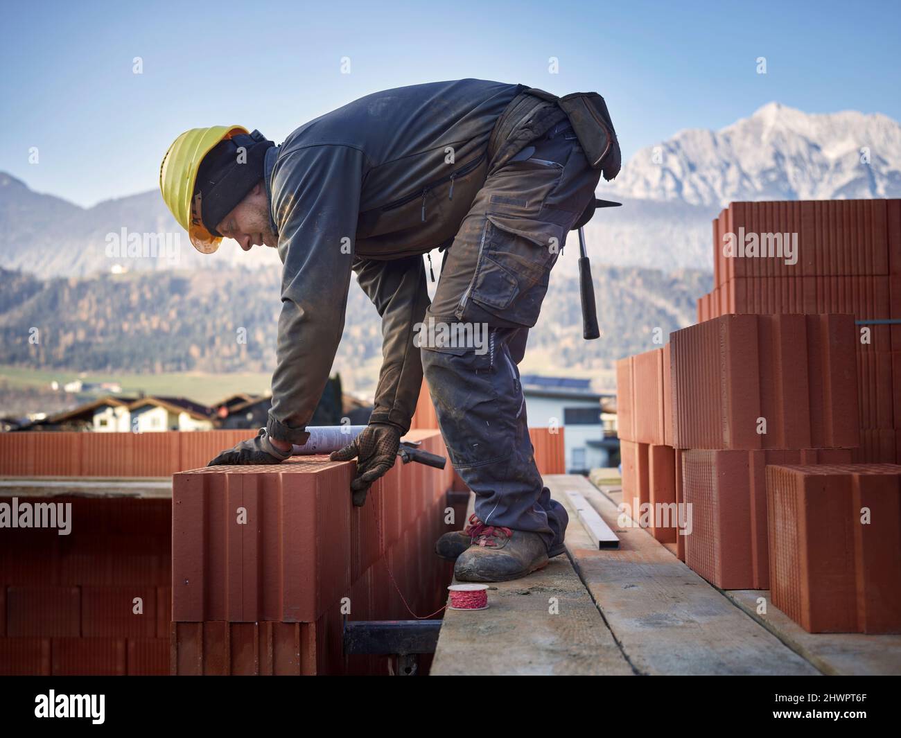 Bricklayer stacking bricks at construction site Stock Photo Alamy