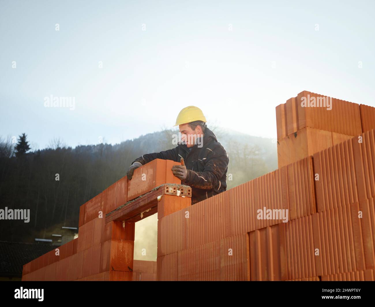 Construction worker fixing bricks at construction site Stock Photo