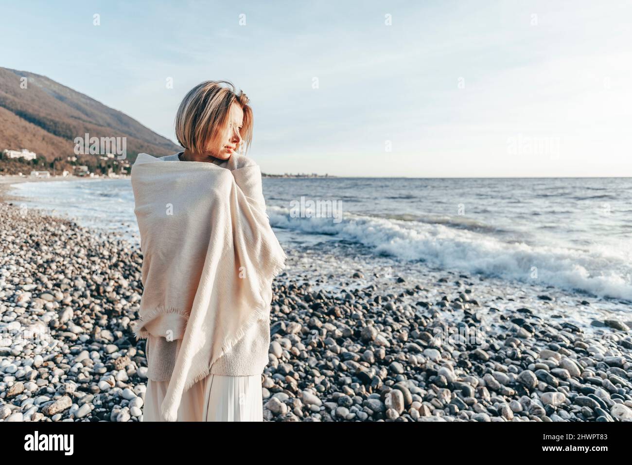 Blond woman wrapped in blanket at beach Stock Photo Alamy