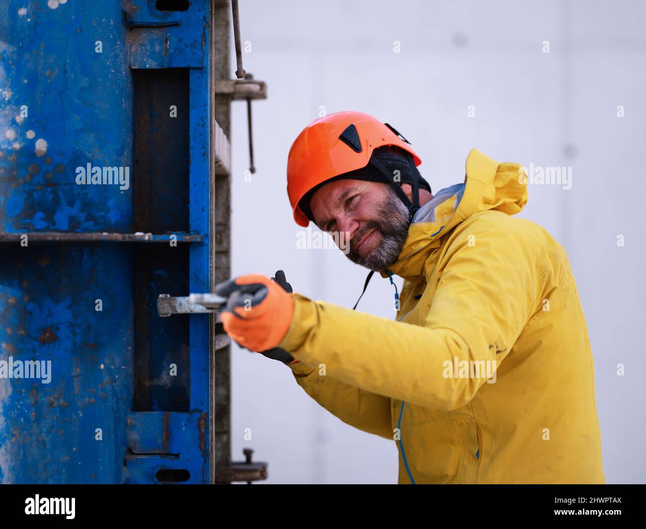 Worker with hardhat examining metal structure at construction Stock Photo