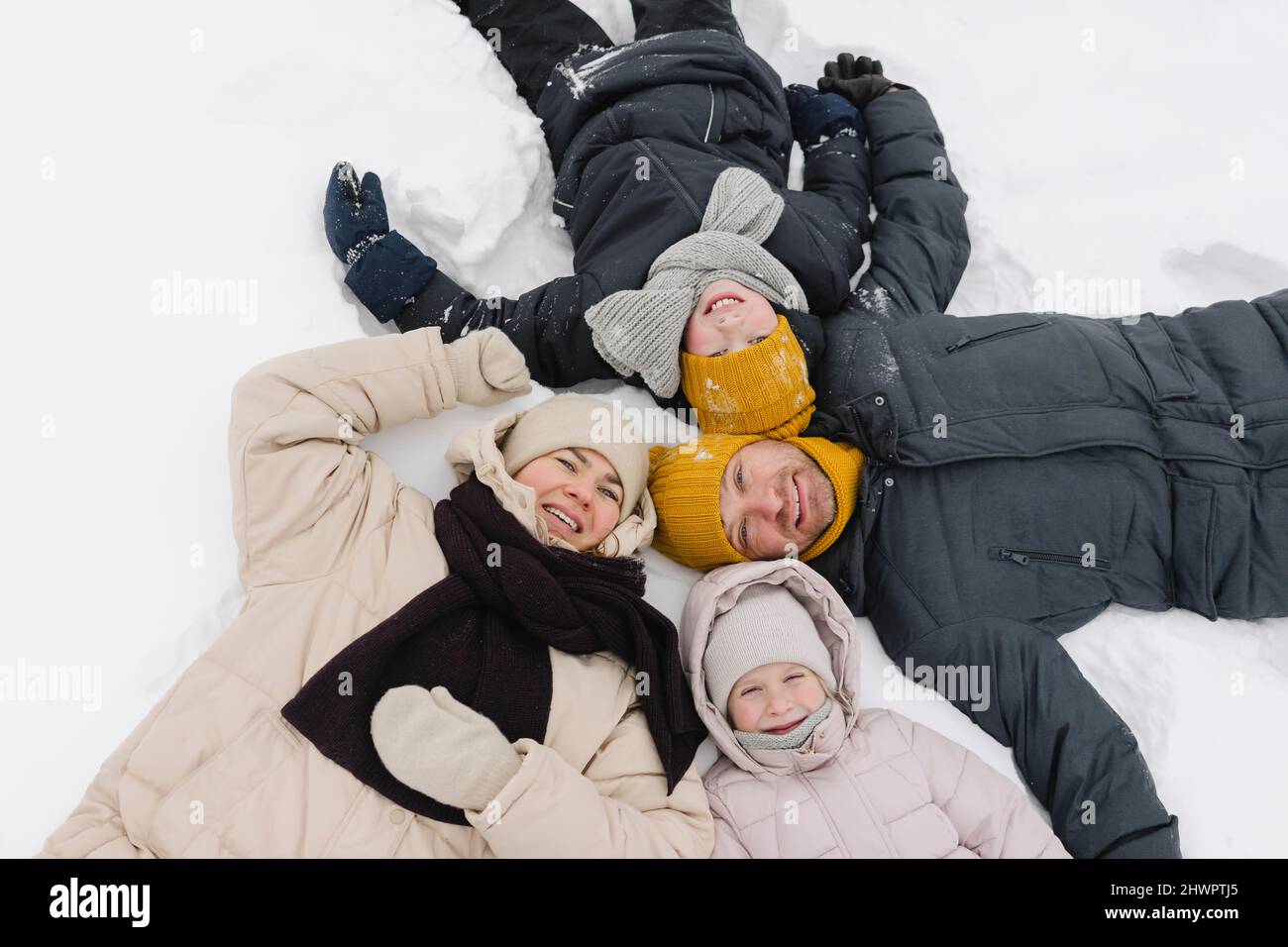 Happy family lying together on snow Stock Photo - Alamy