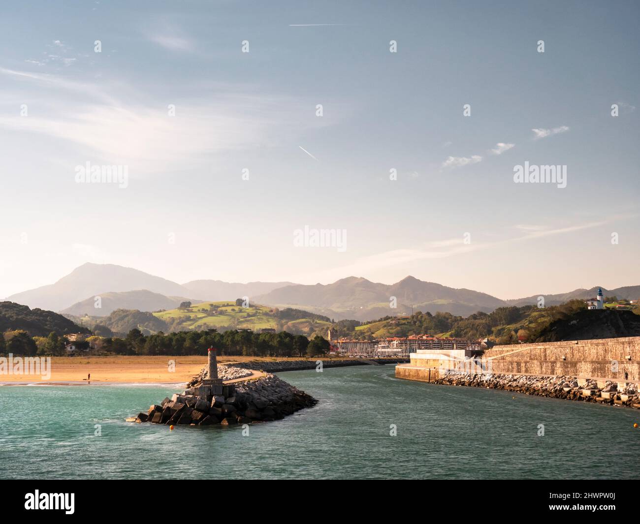 Groyne and lighthouse by beach at Basque Coast Geopark, Basque Country, Spain Stock Photo