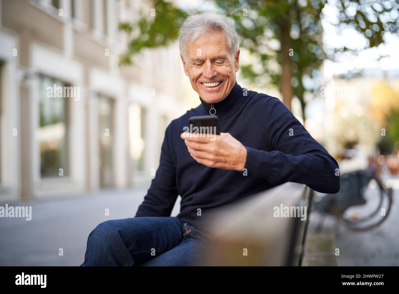 Happy senior man using smart phone in park Stock Photo