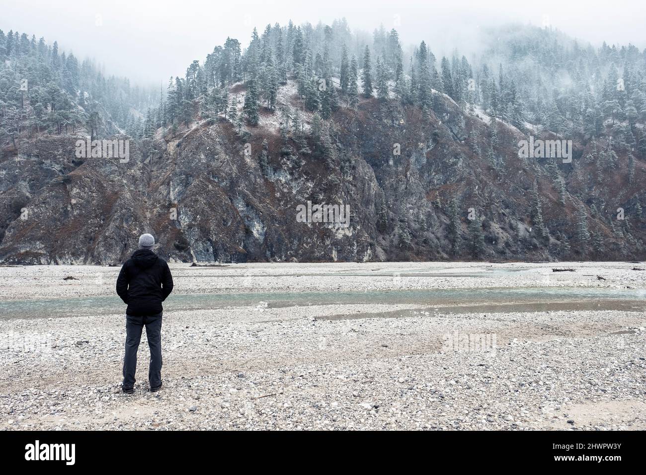 Hiker looking at mountains in winter vacation, Vorderriss, Bavaria, Germany Stock Photo