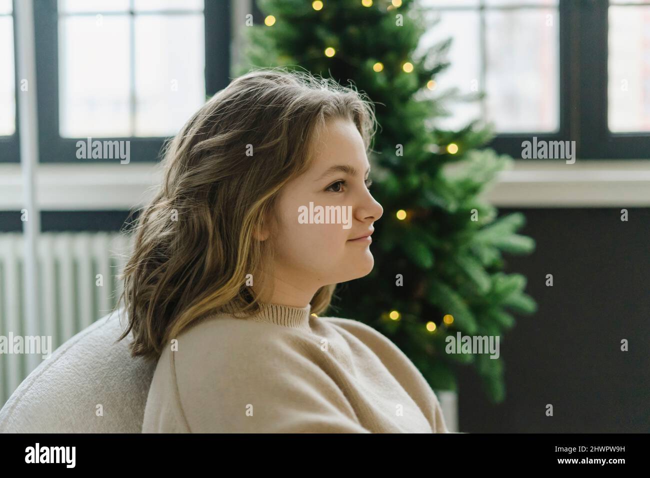 Thoughtful girl in living room at Christmas Stock Photo