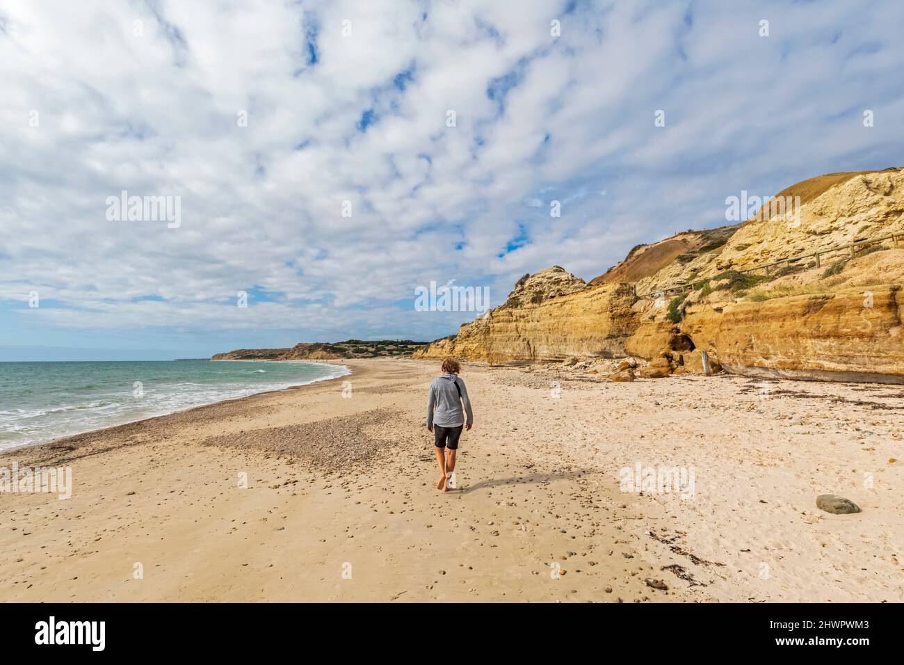 Australia, South Australia, Port Willunga, Female tourist walking alone along Port Willunga Beach Stock Photo