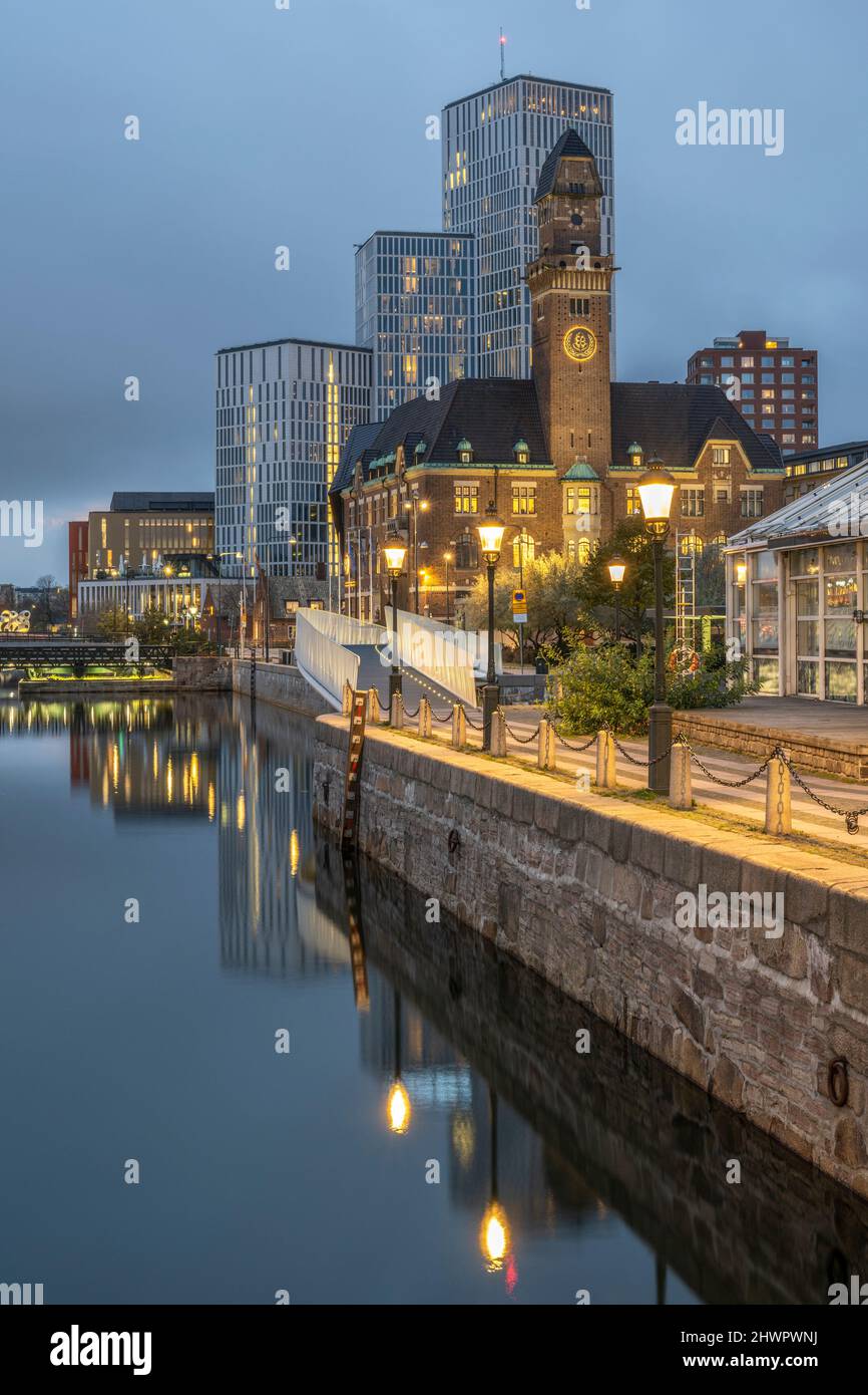 Sweden, Skane County, Malmo, City canal at dusk with World Maritime University and hotels in background Stock Photo