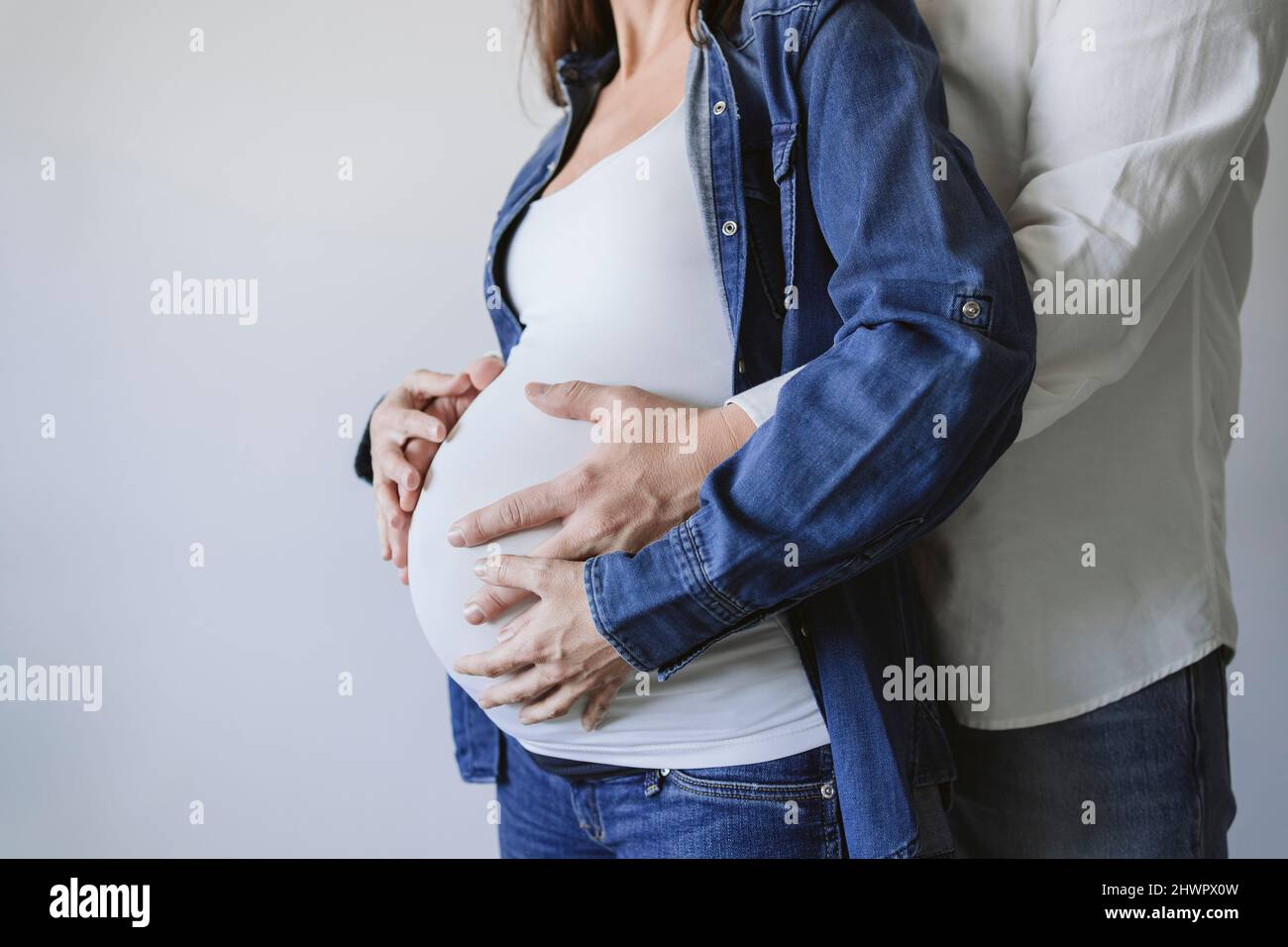 Man embracing pregnant woman by wall Stock Photo - Alamy