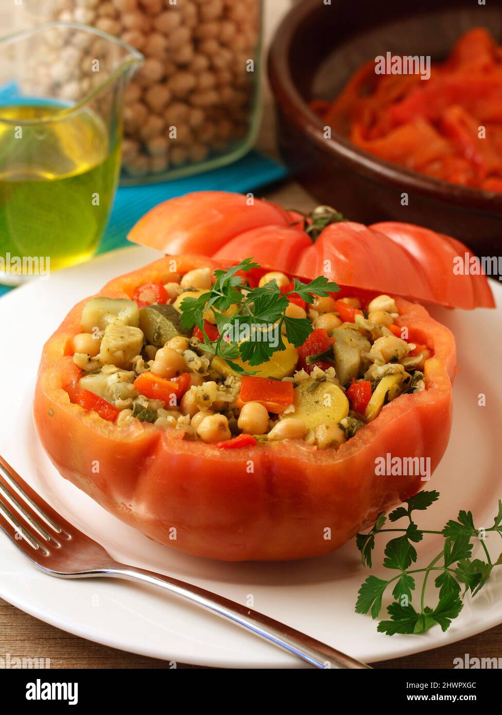 Stuffed tomato with vegetable mix with bulgur wheat, chickpeas and seasoning. Stock Photo