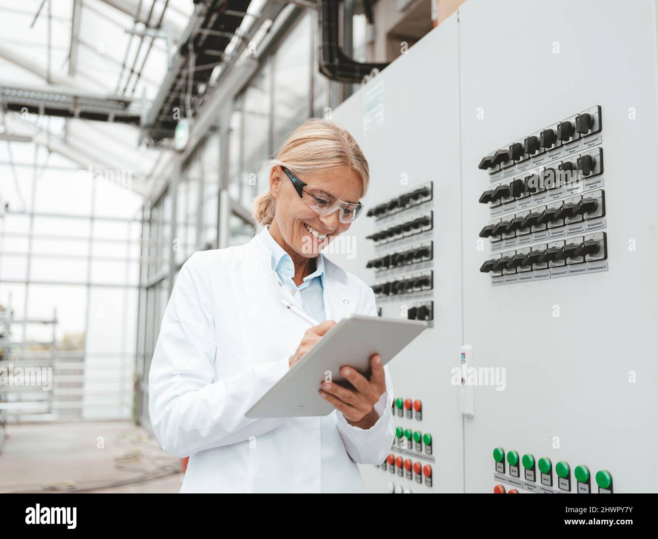 Smiling scientist using tablet PC in industry Stock Photo