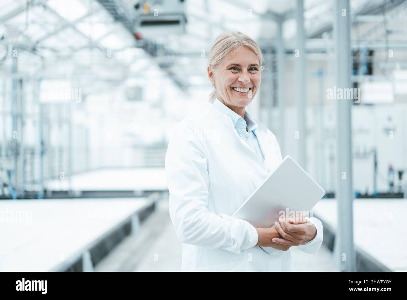 Smiling agronomist with tablet PC in industry Stock Photo