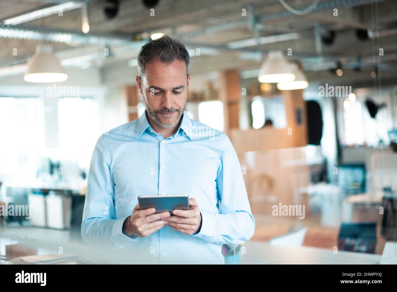 Dedicated working man using tablet computer at workplace Stock Photo