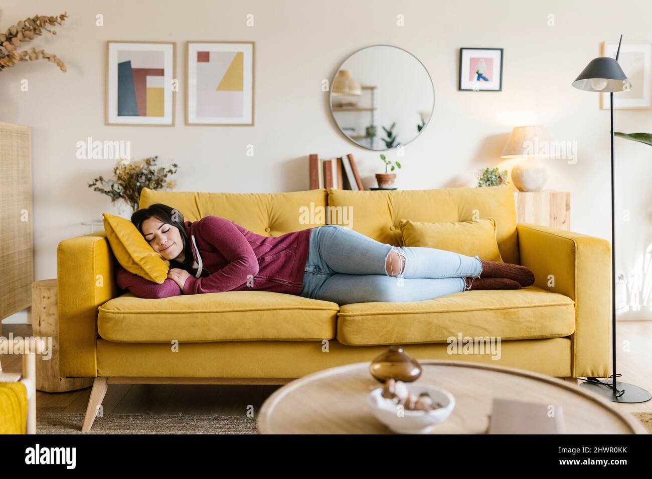 Young woman sleeping on sofa in living room Stock Photo Alamy