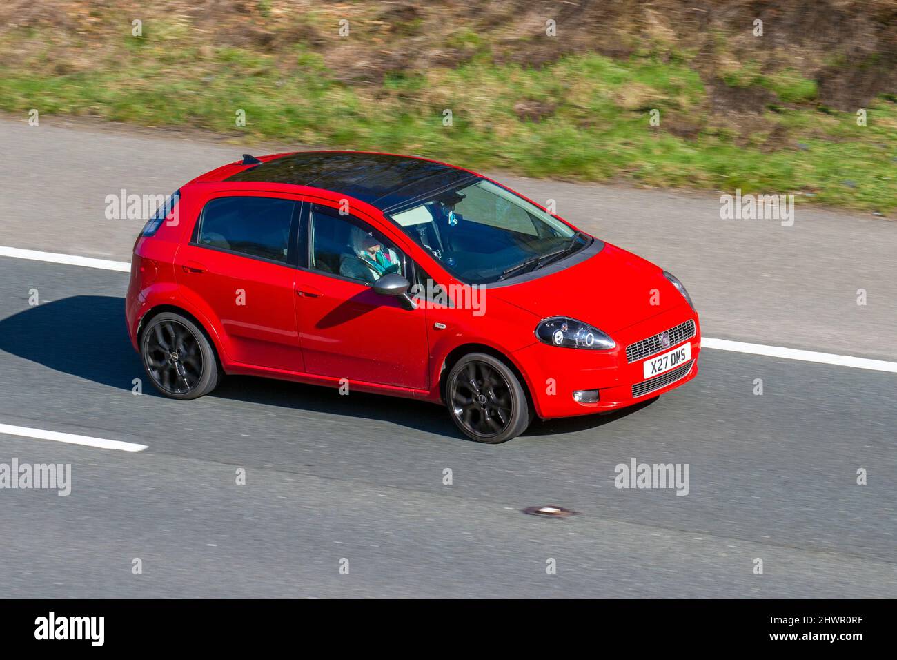 2008 red Fiat Grande Punto 1368cc 5 speed manual; Active Vehicular traffic, moving vehicles, cars, vehicle driving on UK roads, motors, motoring on the M6 motorway highway UK road network. Stock Photo