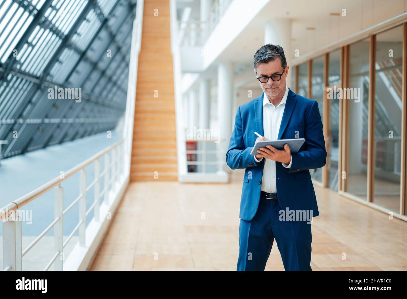 Businessman using tablet PC standing at office Stock Photo
