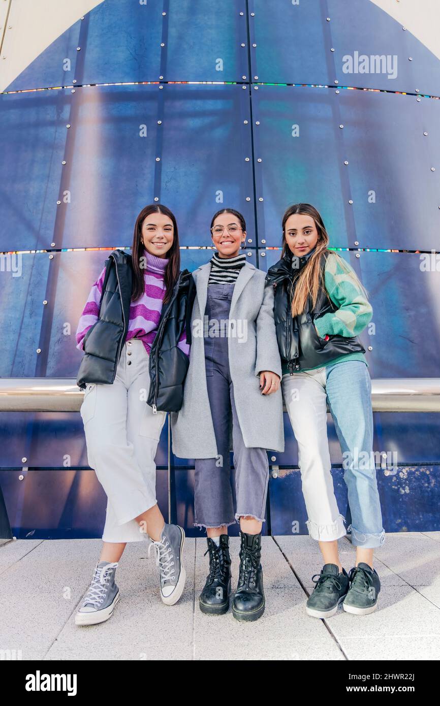 Friends standing together in front of building Stock Photo - Alamy