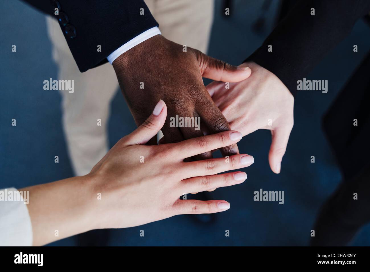 Multi-ethnic business colleagues stacking hands Stock Photo