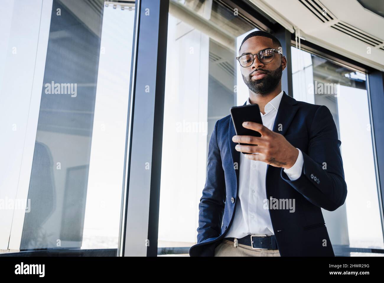 Businessman using smart phone in office Stock Photo