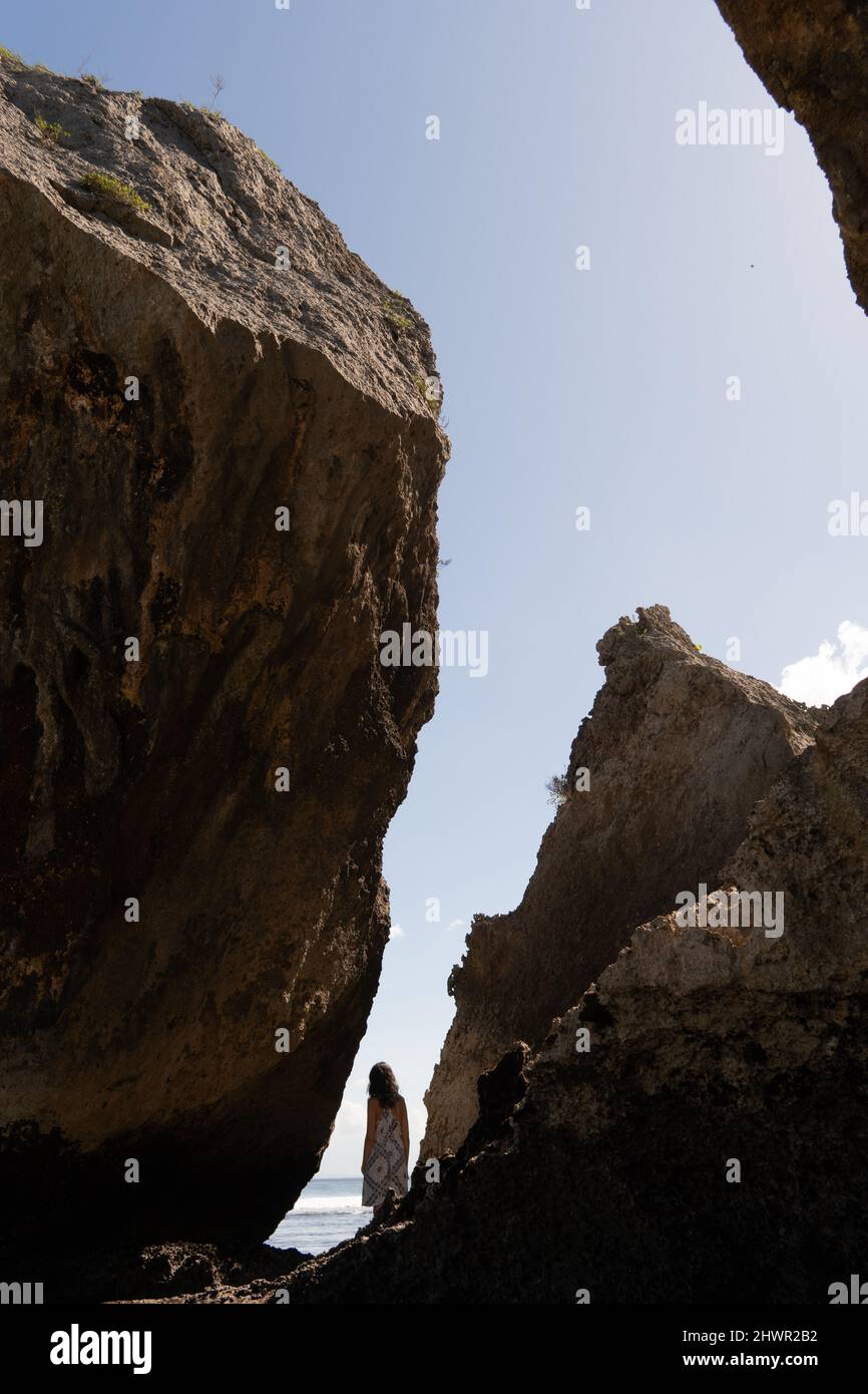A woman standing on the rock and watching the ocean Stock Photo - Alamy