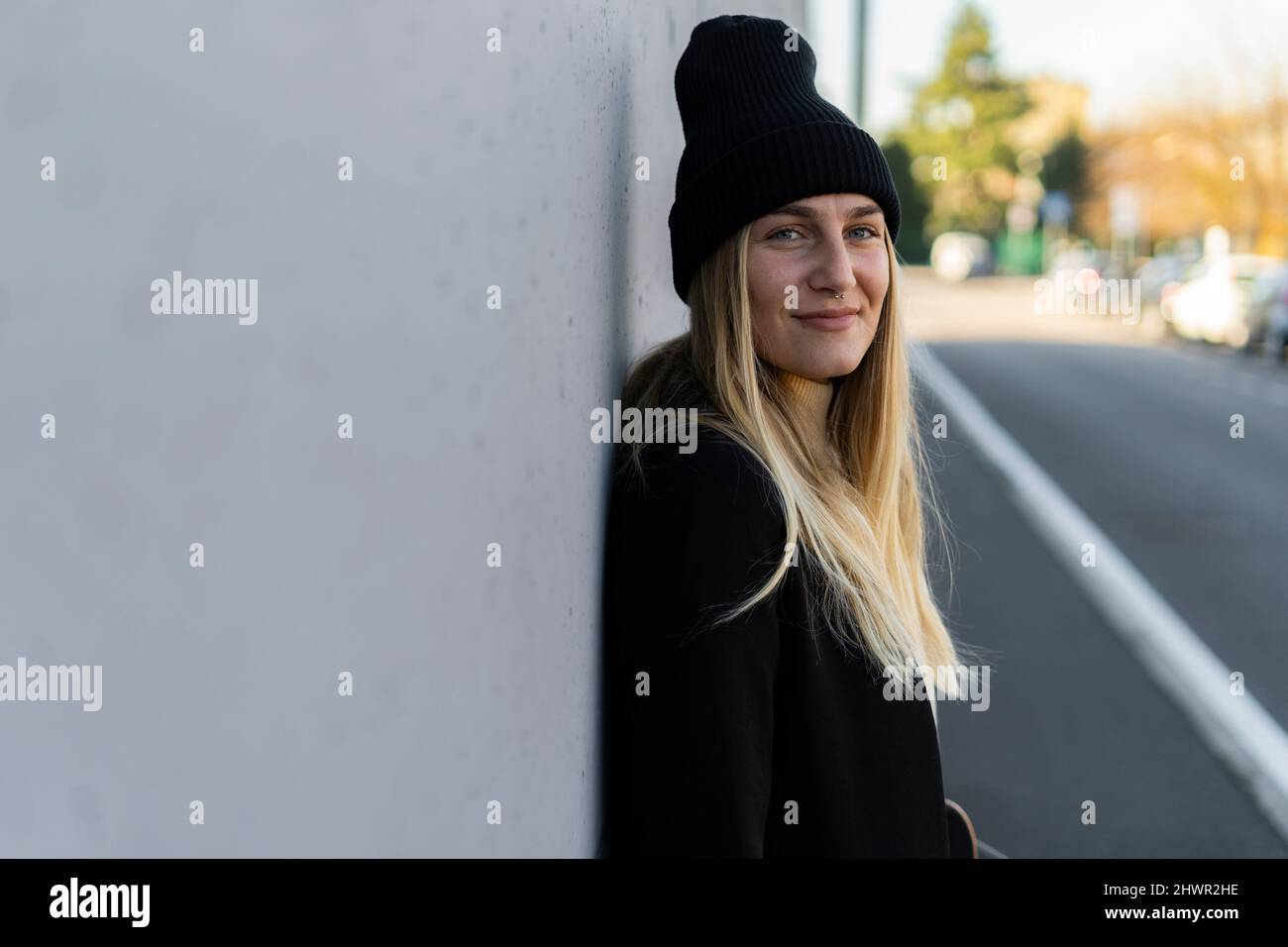 Smiling woman with knit hat on street Stock Photo