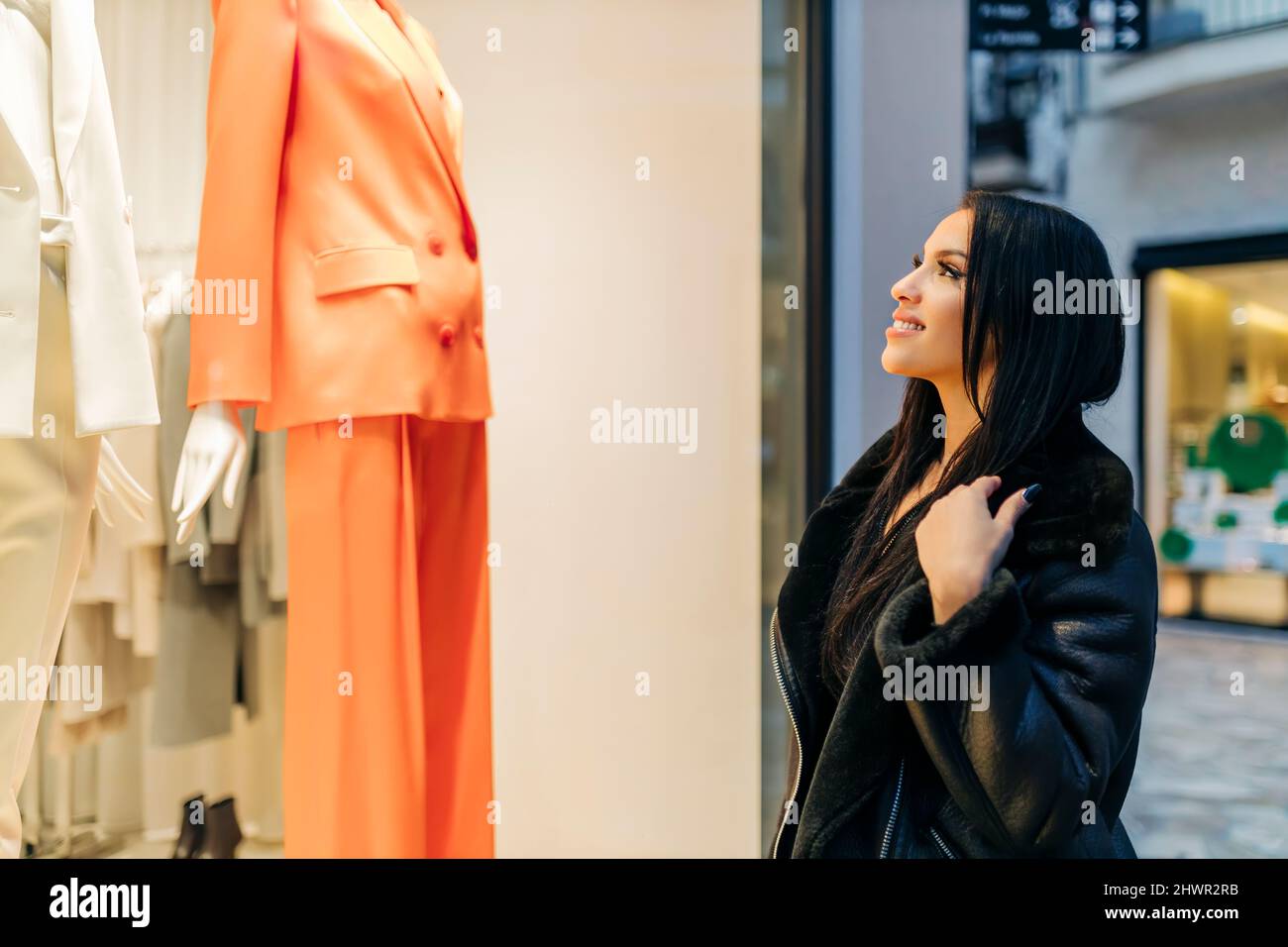 Smiling young woman doing window shopping Stock Photo