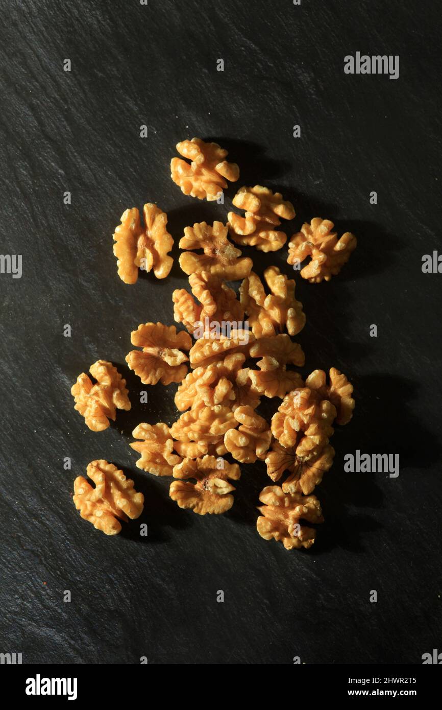 Studio shot of walnut kernels lying against black background Stock Photo