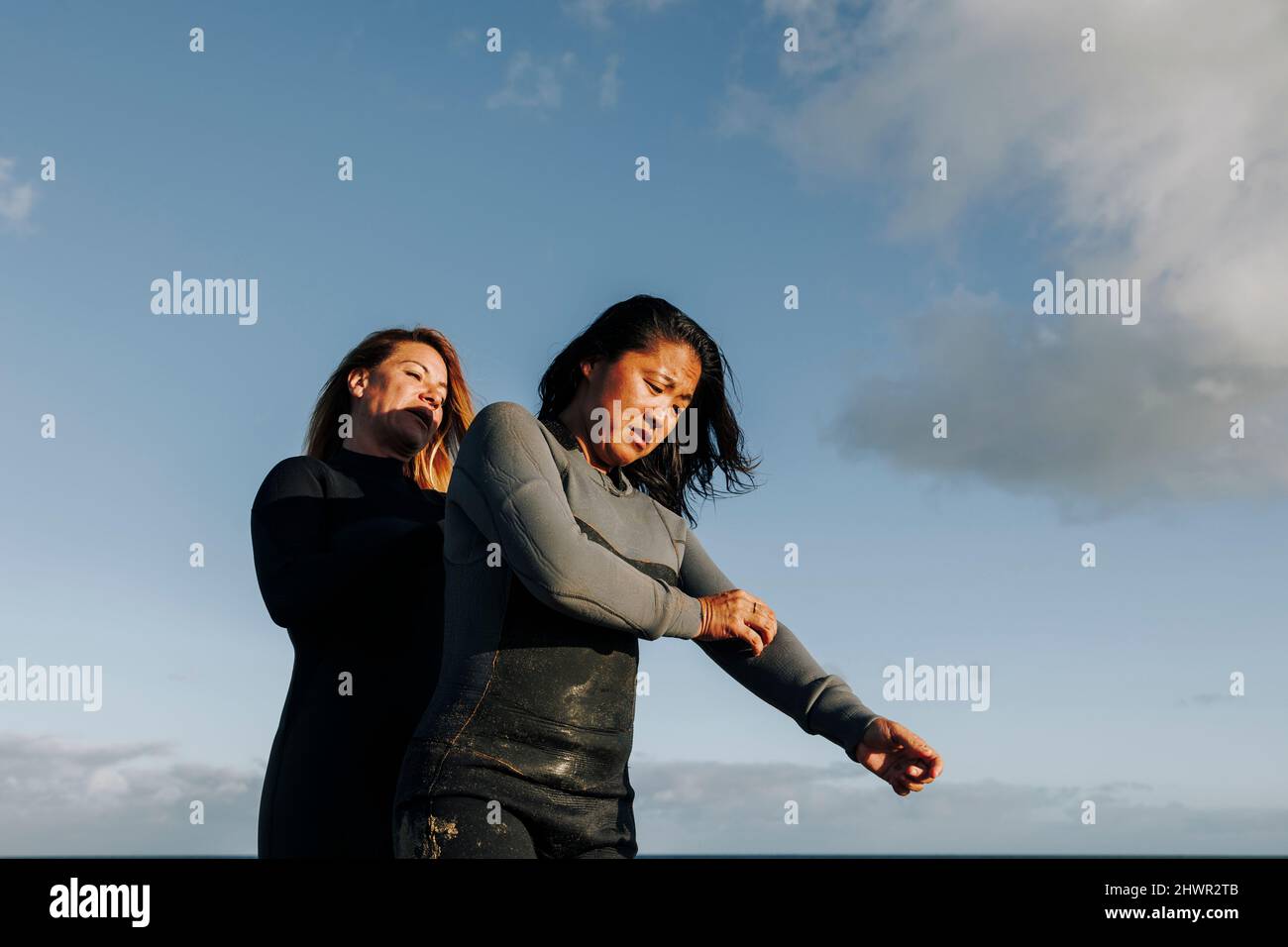 Women wearing wetsuit at beach Stock Photo Alamy