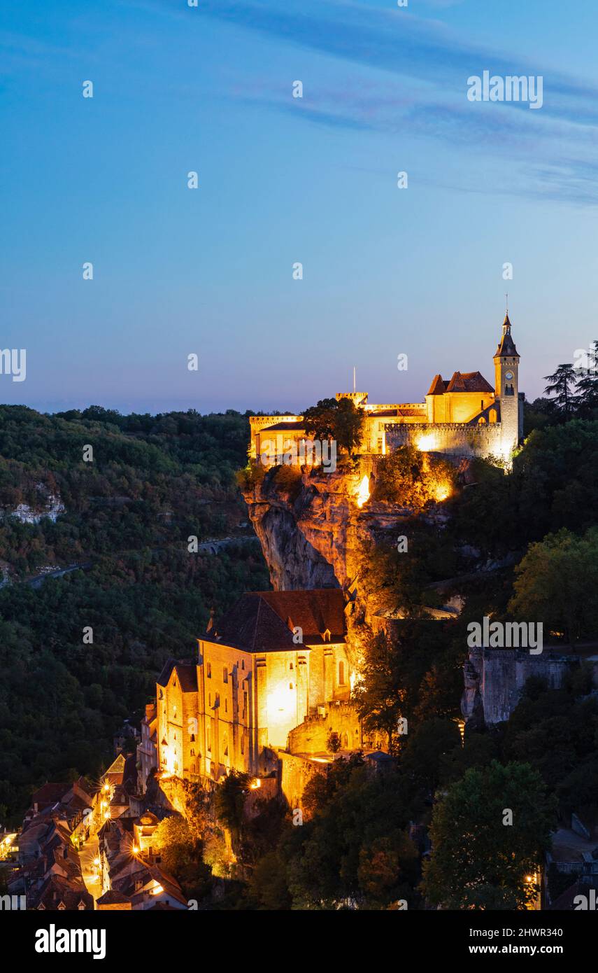 France, Lot, Rocamadour, Illuminated cliffside town at dusk Stock Photo