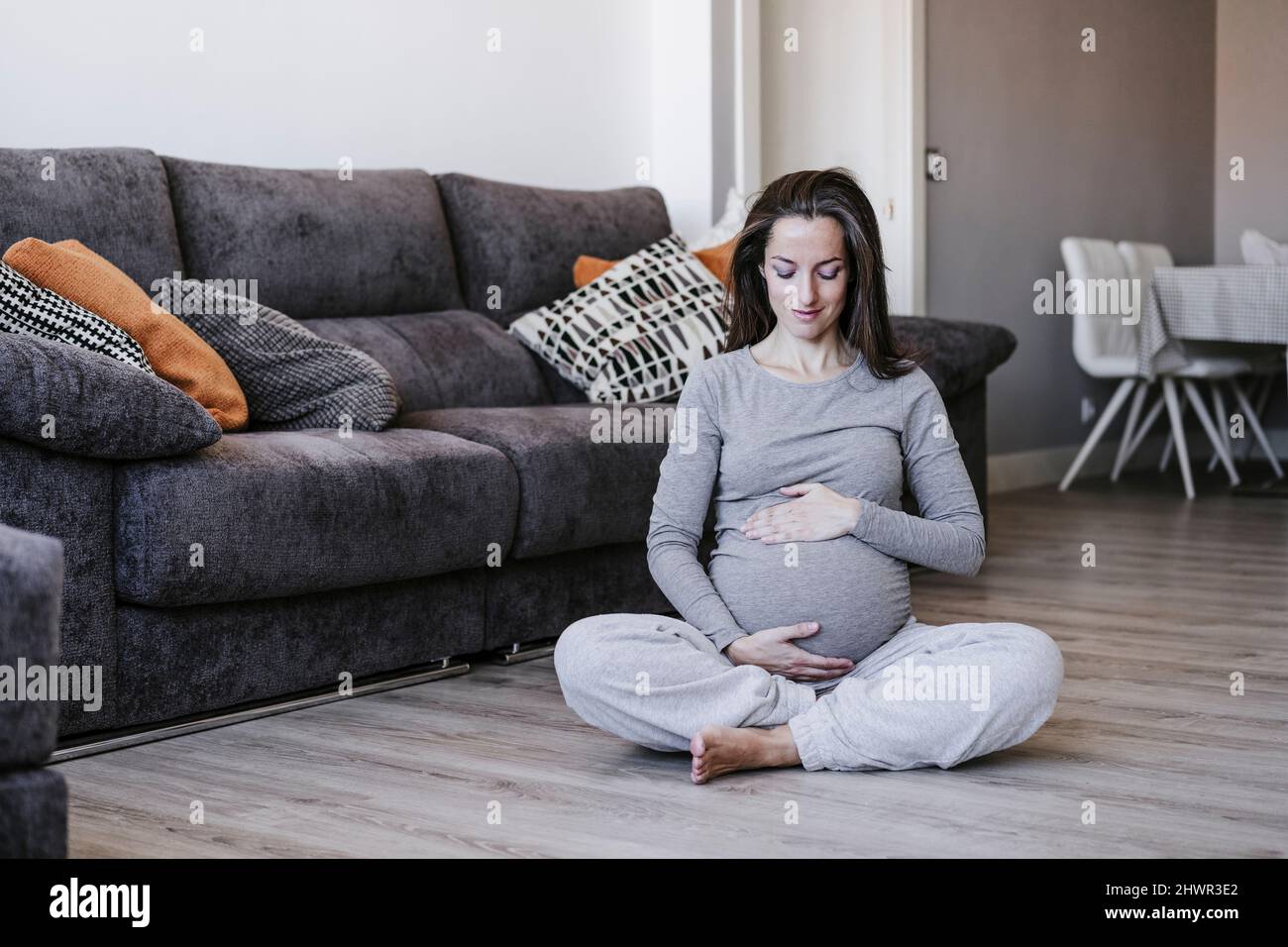 Pregnant woman sitting crosslegged at home Stock Photo Alamy