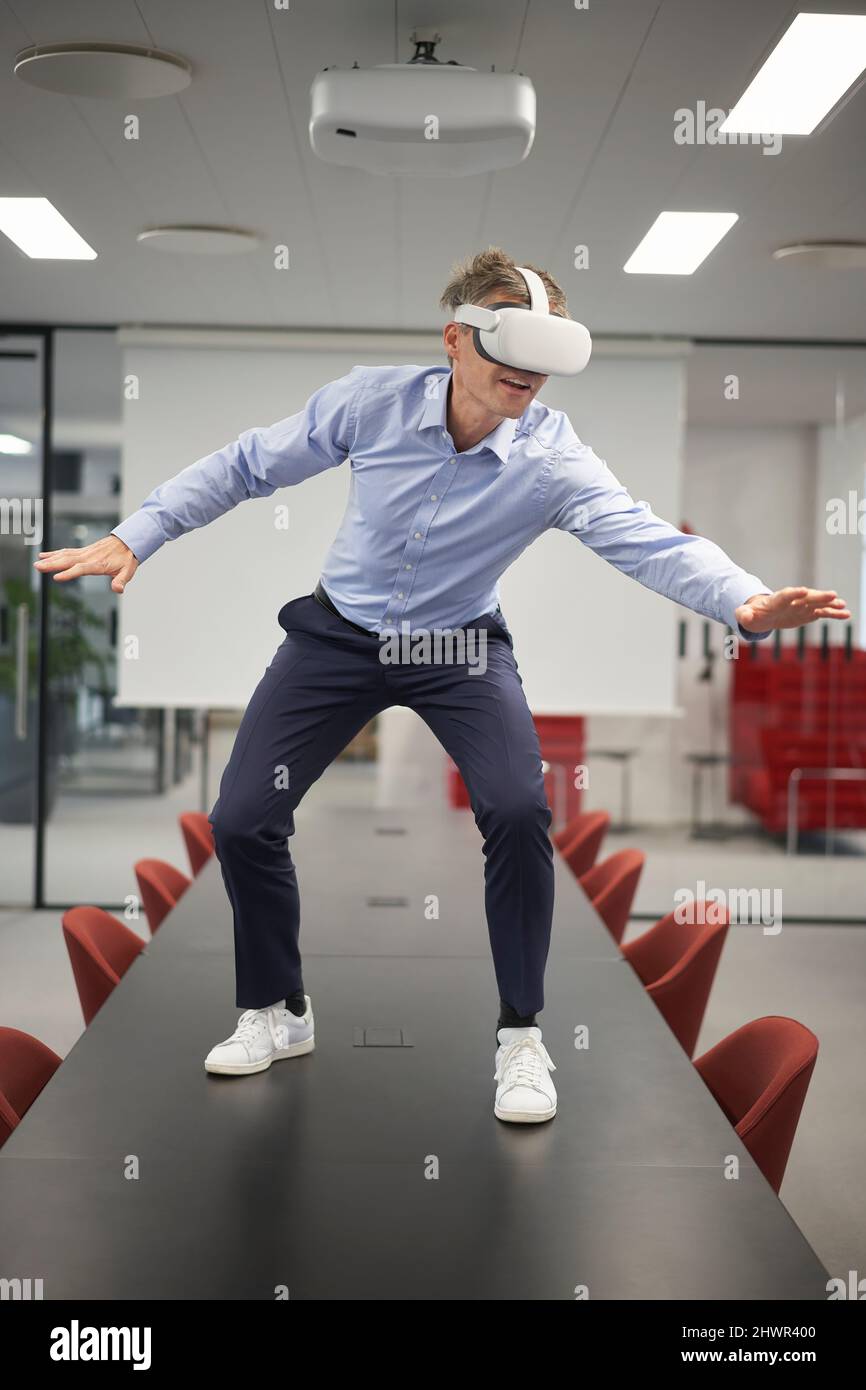 Businessman with VR glasses gesturing in meeting room Stock Photo - Alamy