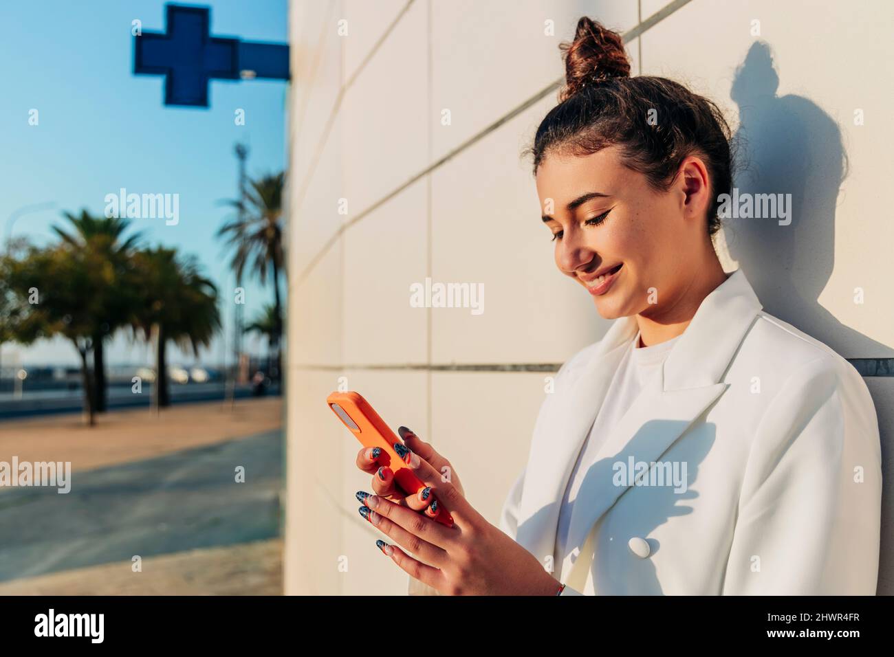Smiling woman using smart phone Stock Photo