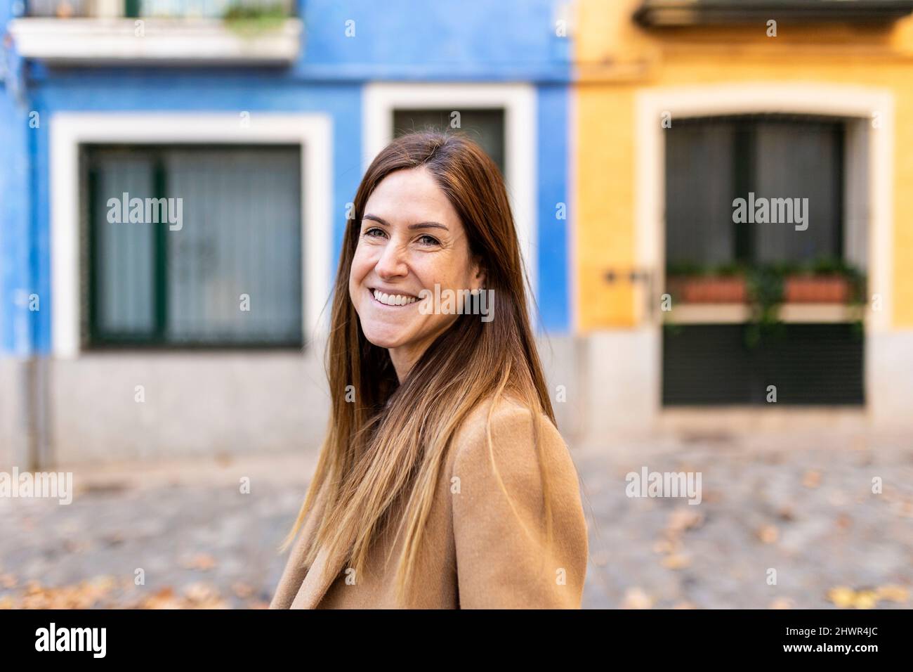 Happy woman with brown hair in city Stock Photo