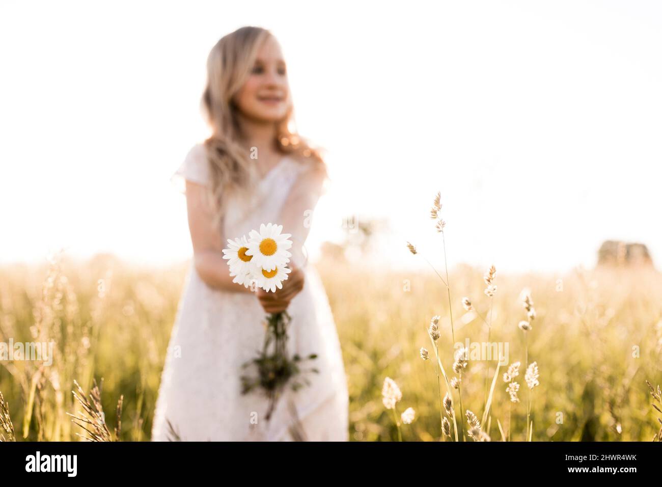 Girl holding daisy flowers in nature Stock Photo