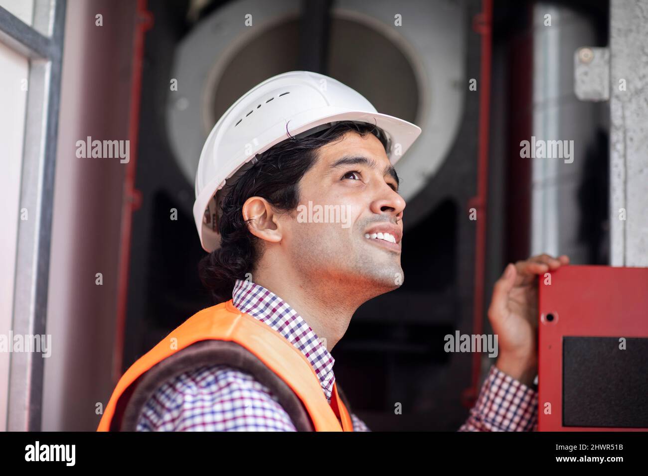 Engineer wearing hardhat working at machinery Stock Photo