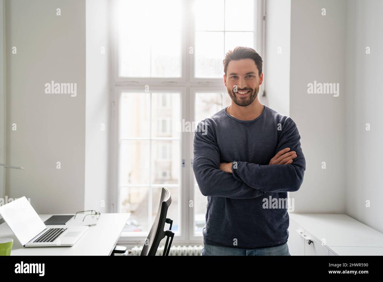Smiling businessman with arms crossed in office Stock Photo - Alamy