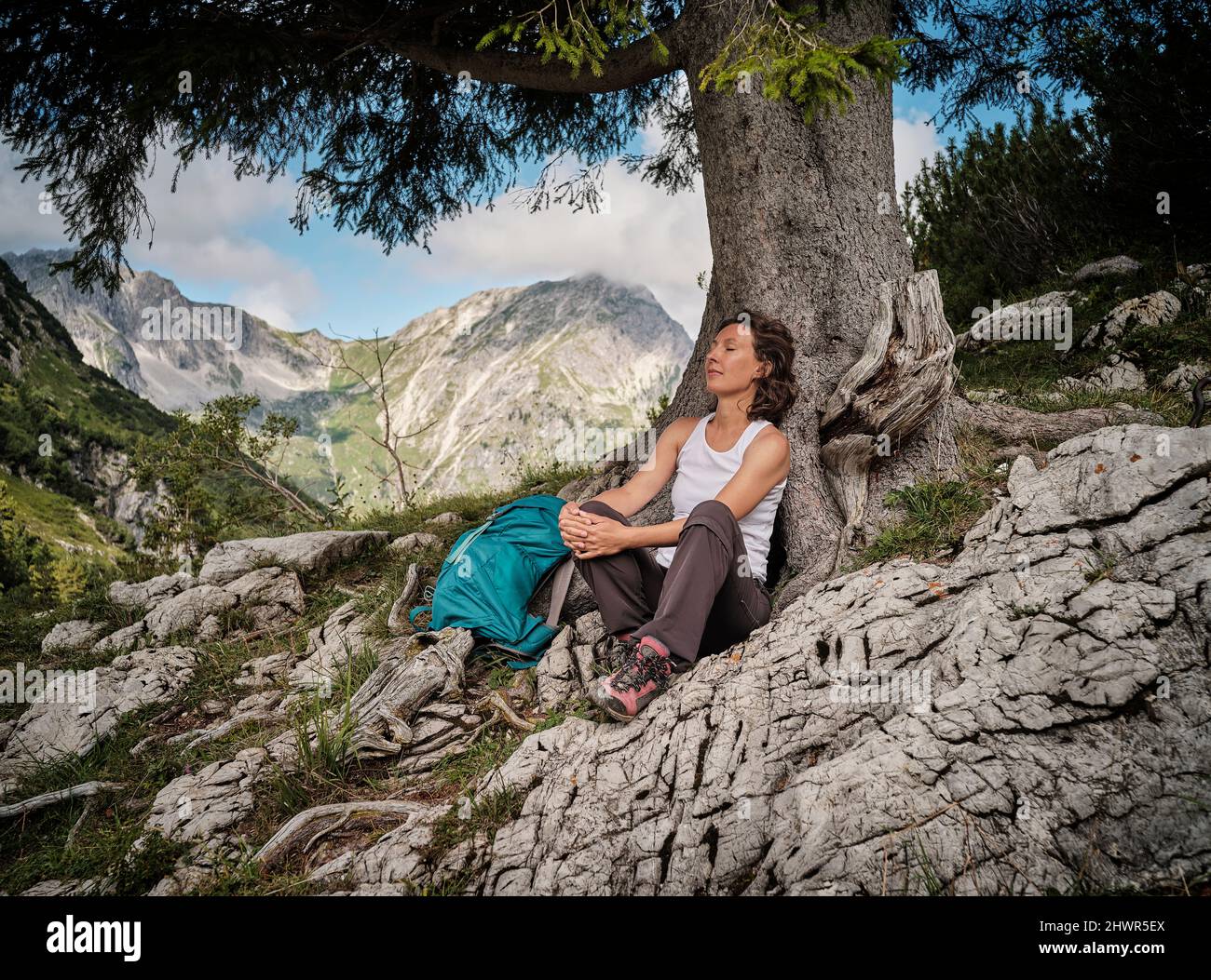 Woman with eyes closed resting by tree Stock Photo - Alamy
