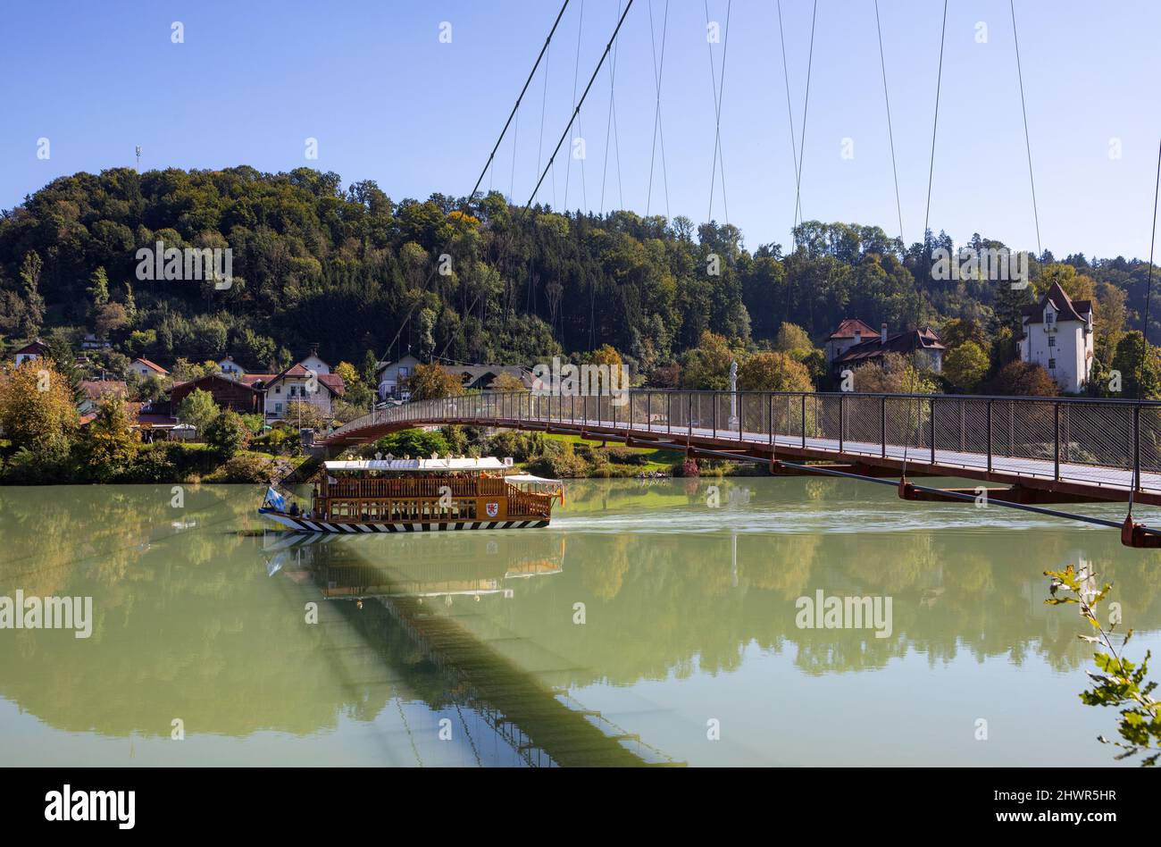 Austria, Upper Austria, Wernstein am Inn, Tourboat sailing under Mariensteg bridge in summer Stock Photo