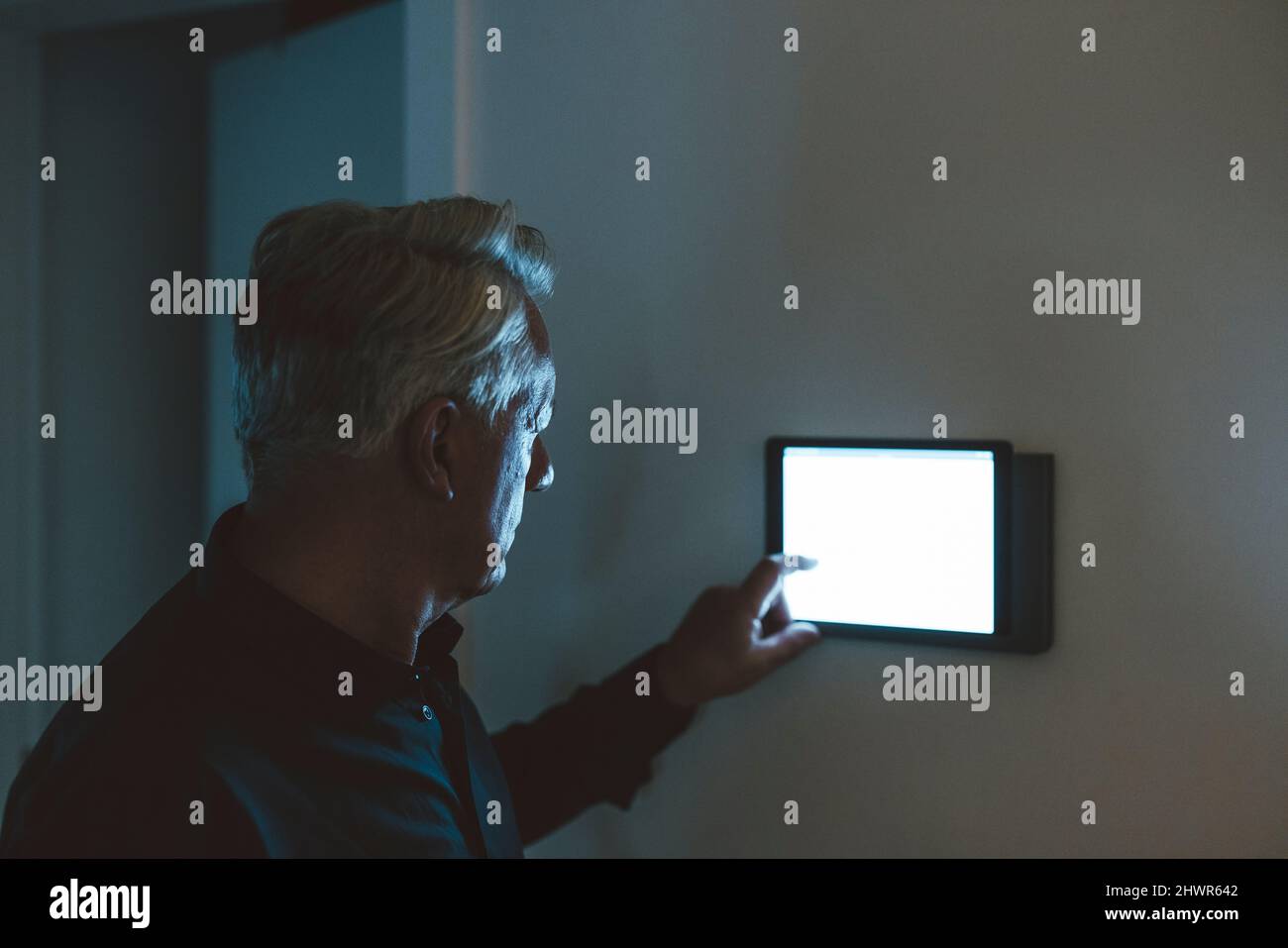 Senior man using smart home app on table PC at home Stock Photo
