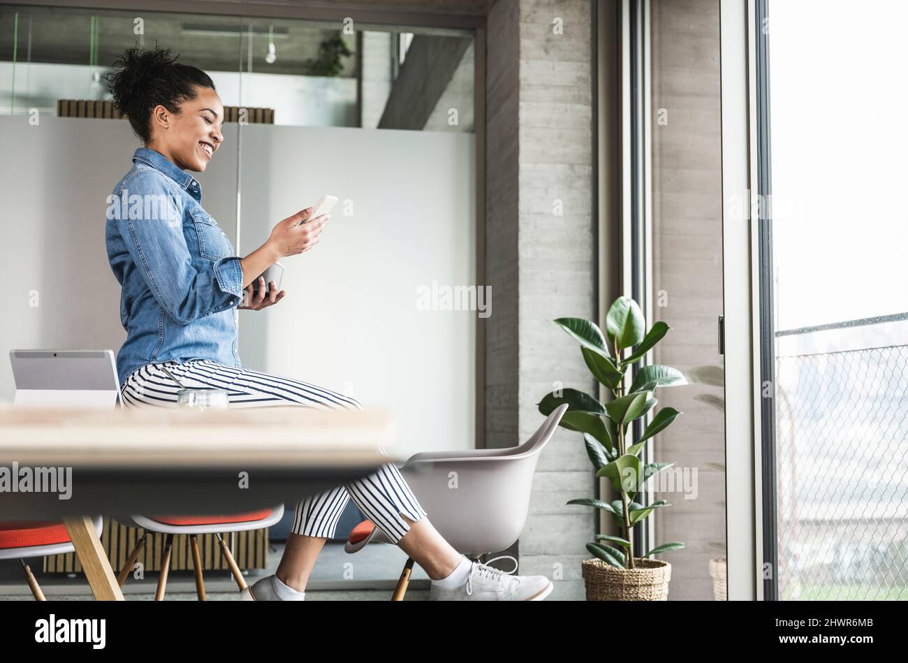 Businesswoman using smart phone at work place Stock Photo
