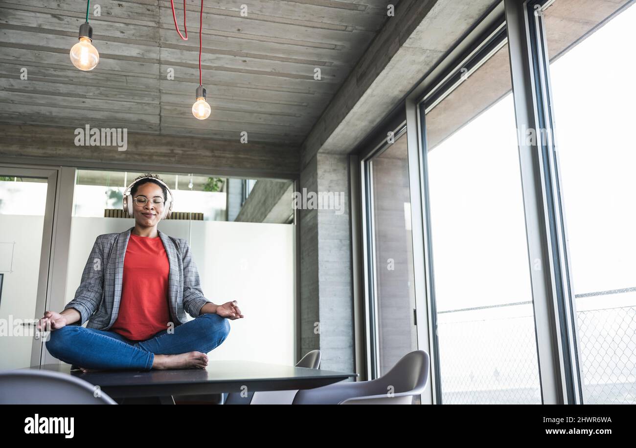 Businesswoman doing yoga at work place Stock Photo