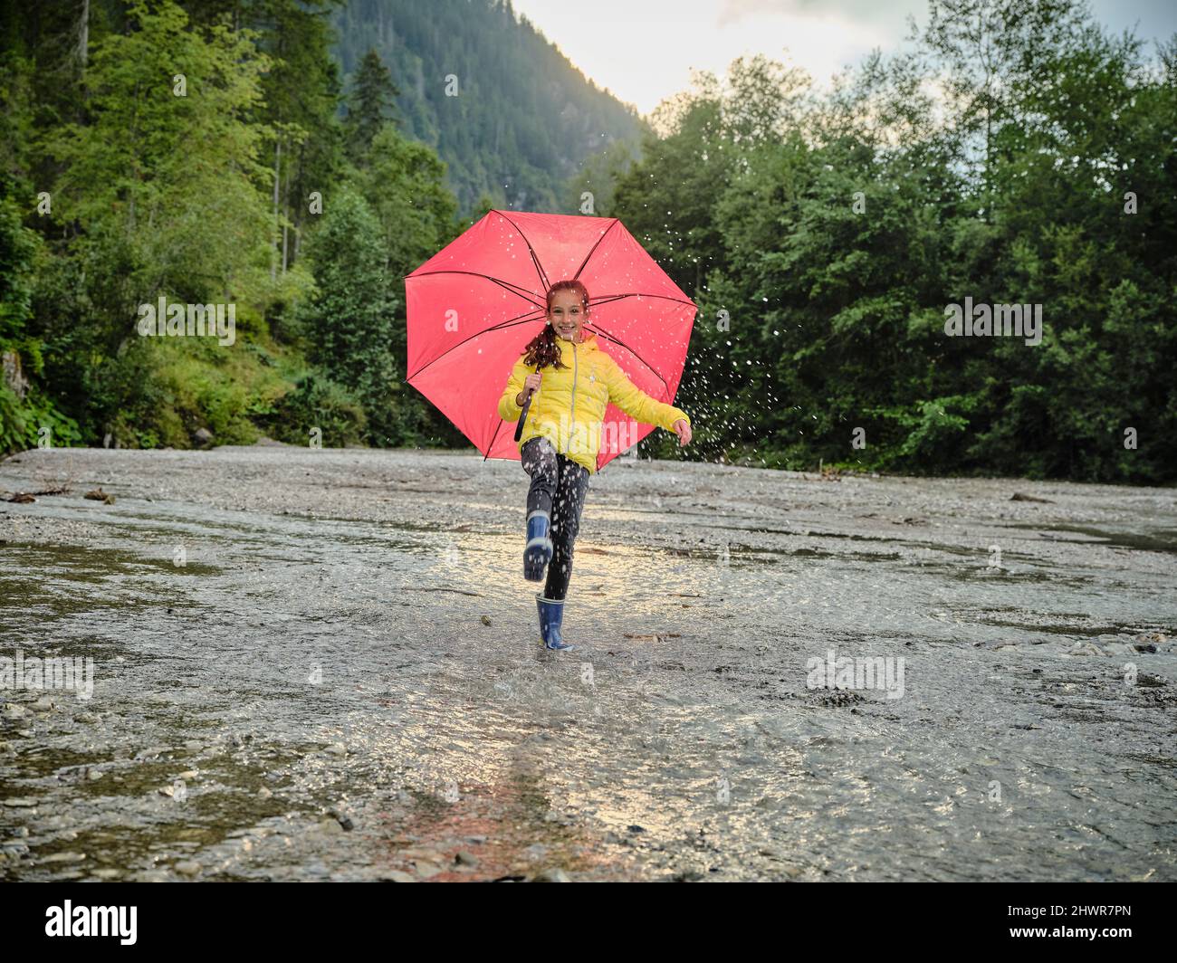 Happy girl holding umbrella hi-res stock photography and images - Alamy