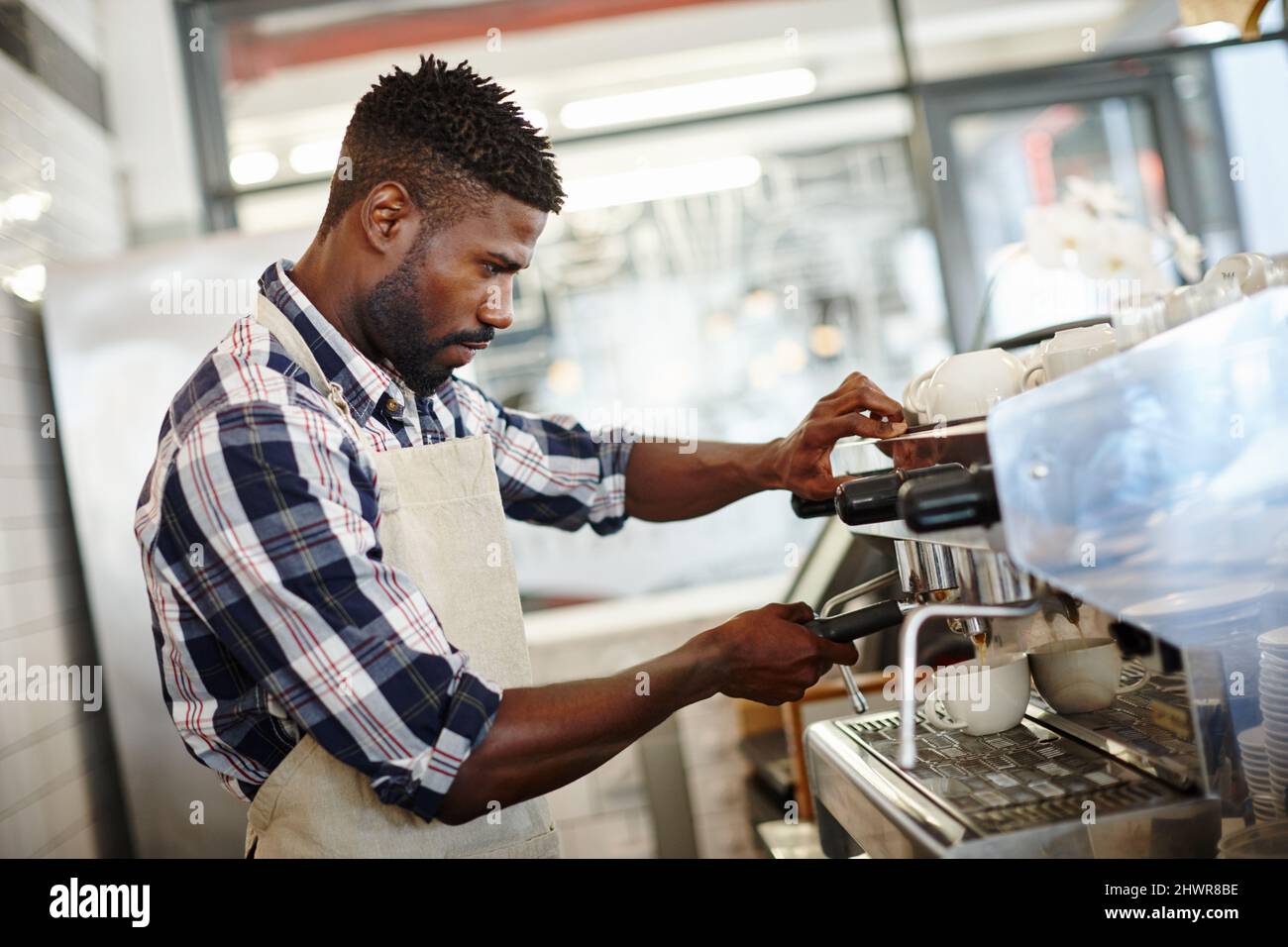 Barista at his best. Shot of a handsome male barista making a cup of