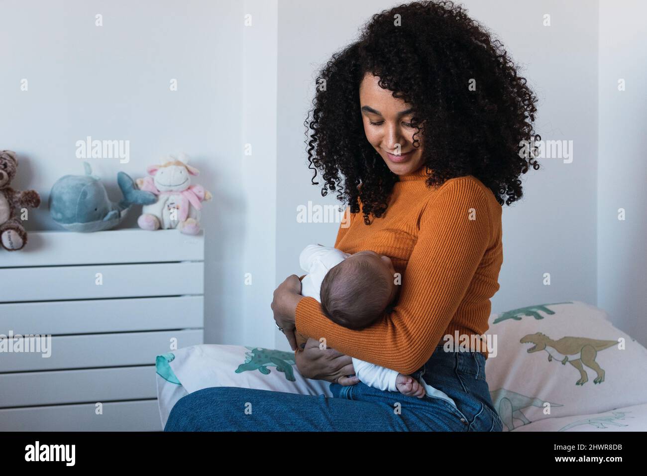 Mother breastfeeding baby boy in bedroom Stock Photo Alamy